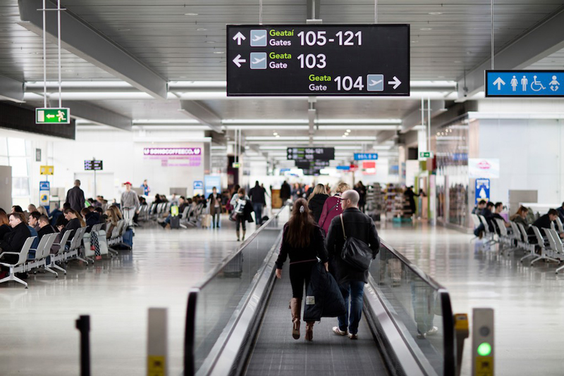 passenger walking with 100 gates signage over head